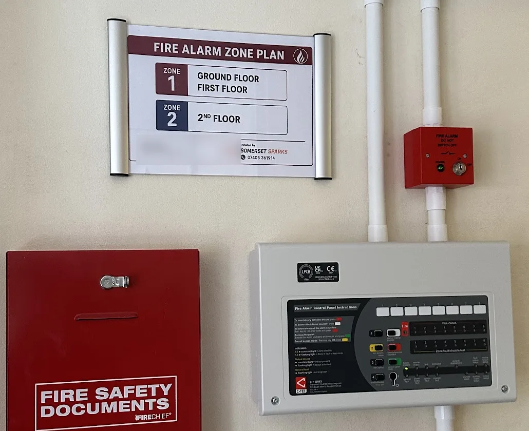 Fire alarm control panel, zone plan, manual call point and fire safety documents box on a completed installation